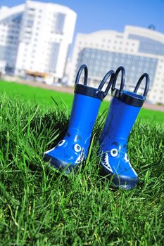 dark blue child rubber boots on a grass in a spring day