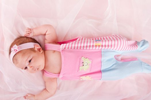 View of a newborn baby on smooth bed.