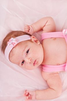 View of a newborn baby on smooth bed.
