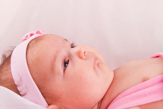 View of a newborn baby on smooth bed.