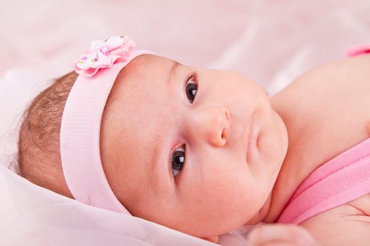 View of a newborn baby on smooth bed.