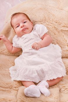 View of a newborn baby on a smooth bed.