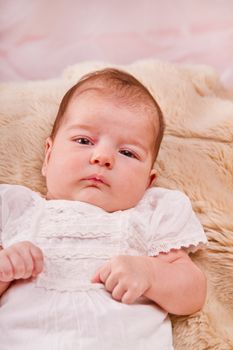 View of a newborn baby on a smooth bed.