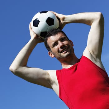 young man with ball and blue sky in summer