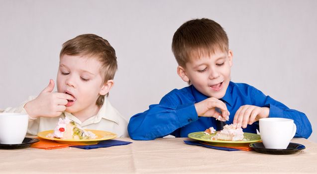 two boys eating a cake his hands