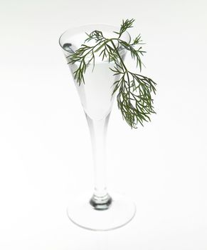 Glass of aquavitwith dill isolated on white background