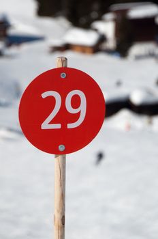 Number 29 on red sign next to ski slope in Montafon, Austria