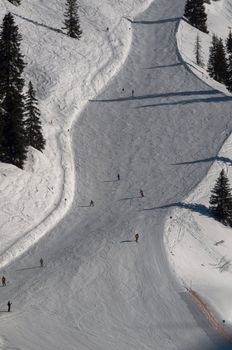 Snow covered ski piste surrounded by trees on sunny day at Montafon, Austria