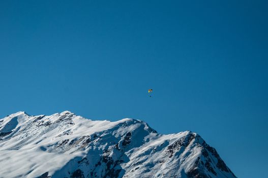 Beautiful winter mountain panorama with paraglider in Montafon, Austria