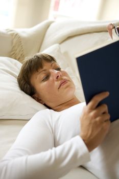 Woman in the sofa reading a book