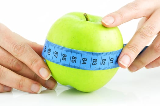 Woman's hands holding bright green apple and measuring tape isolated on a white background