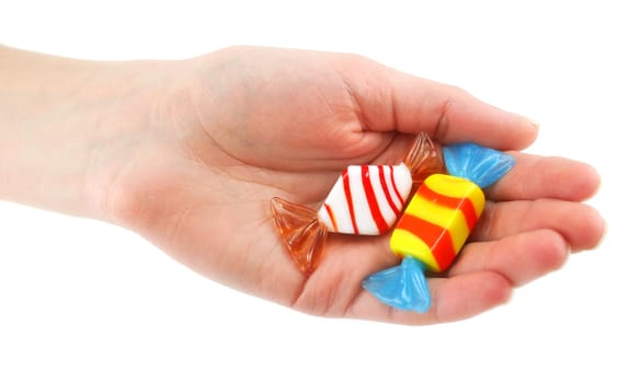 Woman's hand gives two colored candy isolated on a white background