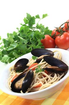 Spaghetti with tomatoes and mussels on a light background