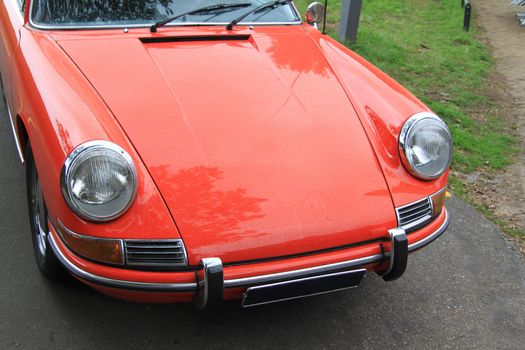 vintage red sportscar of German make, covered with raindrops