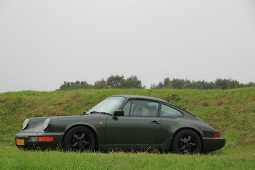 A classic green sportscar parked on the grass