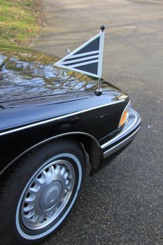 Detail of a black American hearse, black flags with white lining