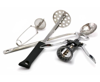 Two perforated spoons, tea strainer and corkscrew isolated on a white background