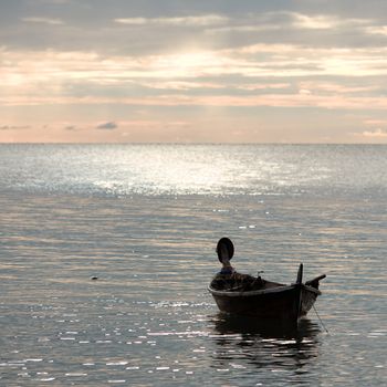 abandoned boat on waves under sunset, Andaman Sea, Thailand