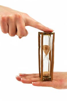 Female hand holds and denotes hourglass (isolated)