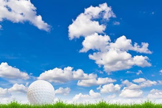 golf ball on green grass against blue sky