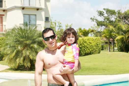 Father and daughter beside the swimming pool