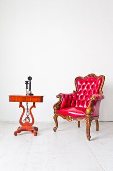 vintage red luxury armchair and telephone in white room