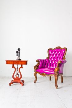 vintage purple luxury armchair and telephone in white room