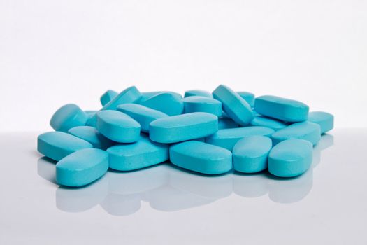 a bunch of blue pills on a white background