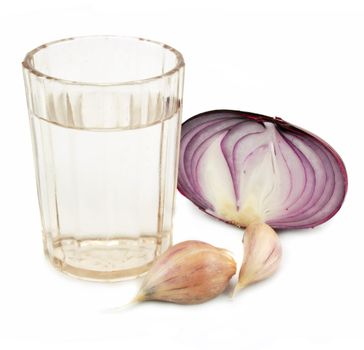 Glass of alcohol, garlic and onion isolated on a white background