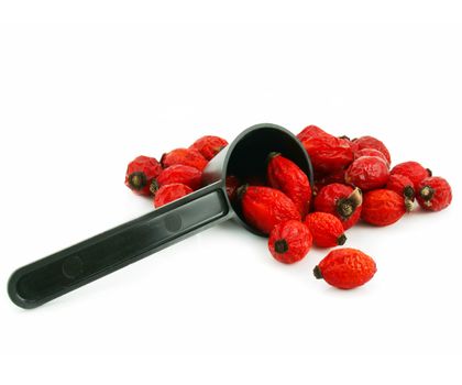 Rose hips and measuring spoon isolated on a white background