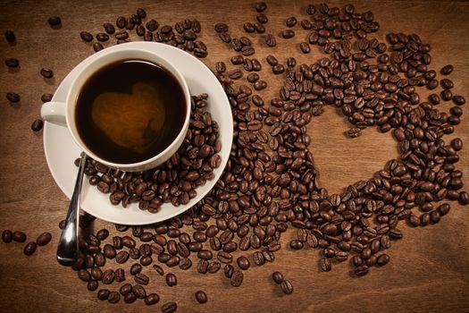 Heart shape from coffee beans on wood background