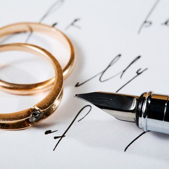 An image of two rings and a pen on a letter