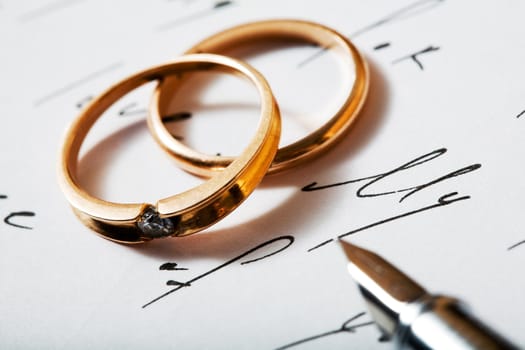 Stock photo: an image of two golden rings and a pen