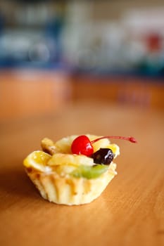 Cupcake with cherry on top on wooden table. Selective focus. Make with Canon 35 1.4
aperture 1.4 was used for small DOF
