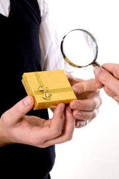Stock photo: an image of a yellow box in hands of a man and a magnifier