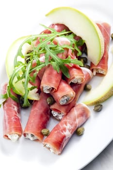 Parma ham rolls filled with cream cheese, Galia melon and capers