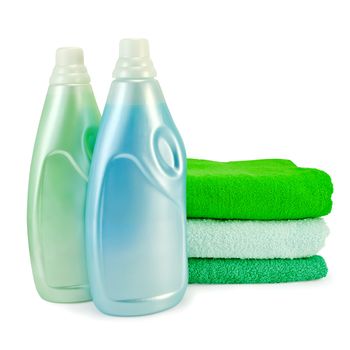 Two bottles of fabric softener blue and green colors, a stack of three towel isolated on white background