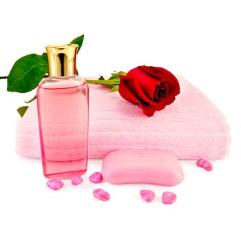 Bottle of pink shower gel, pink soap, towels, bath salt and red roses isolated on white background