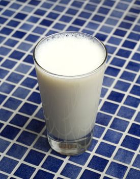 Glass of Milk towards blue mosaic