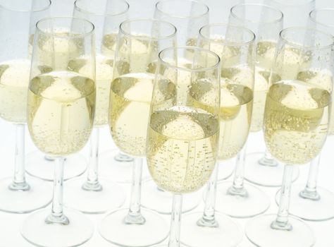 Glasses of champagne on white background