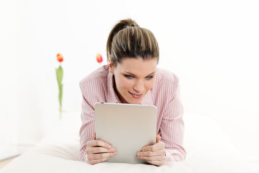 young woman with tablet on sofa at home