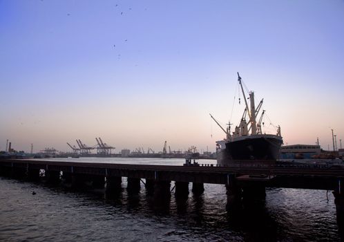 Cargo ship in the harbor at sunset 