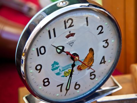 shinny alarm clock with  black and red hands