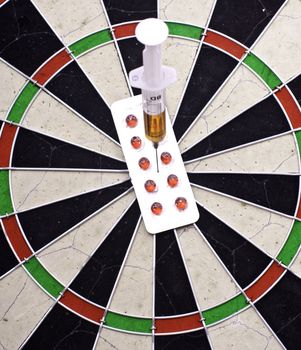 syringe  in target on darts board