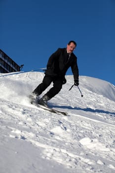 Man in business sute on ski going down
