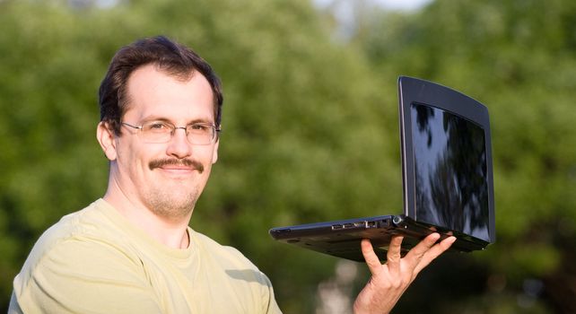 Man with notebook lying on the grass in park