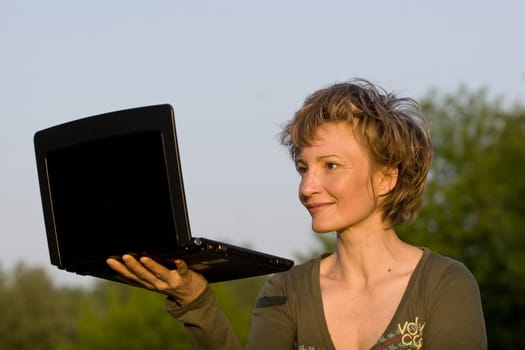 Woman with notebook lying on the grass in park