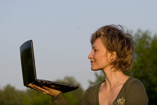 Woman with notebook lying on the grass in park