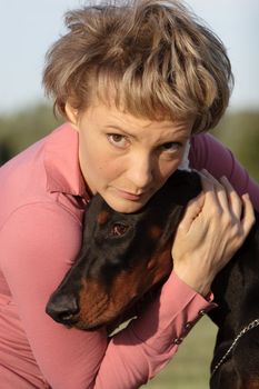 Young woman with old dobermann dog