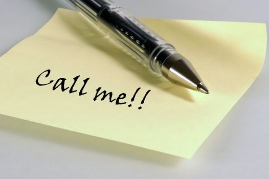 A yellow post-it note with the word 'Call me'